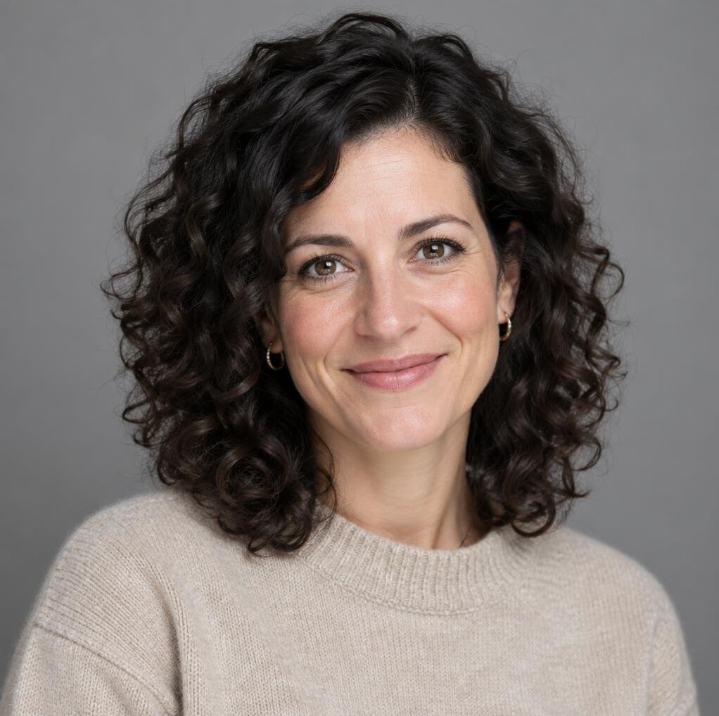 Studio portrait of a Swiss woman editor with dark curly hair