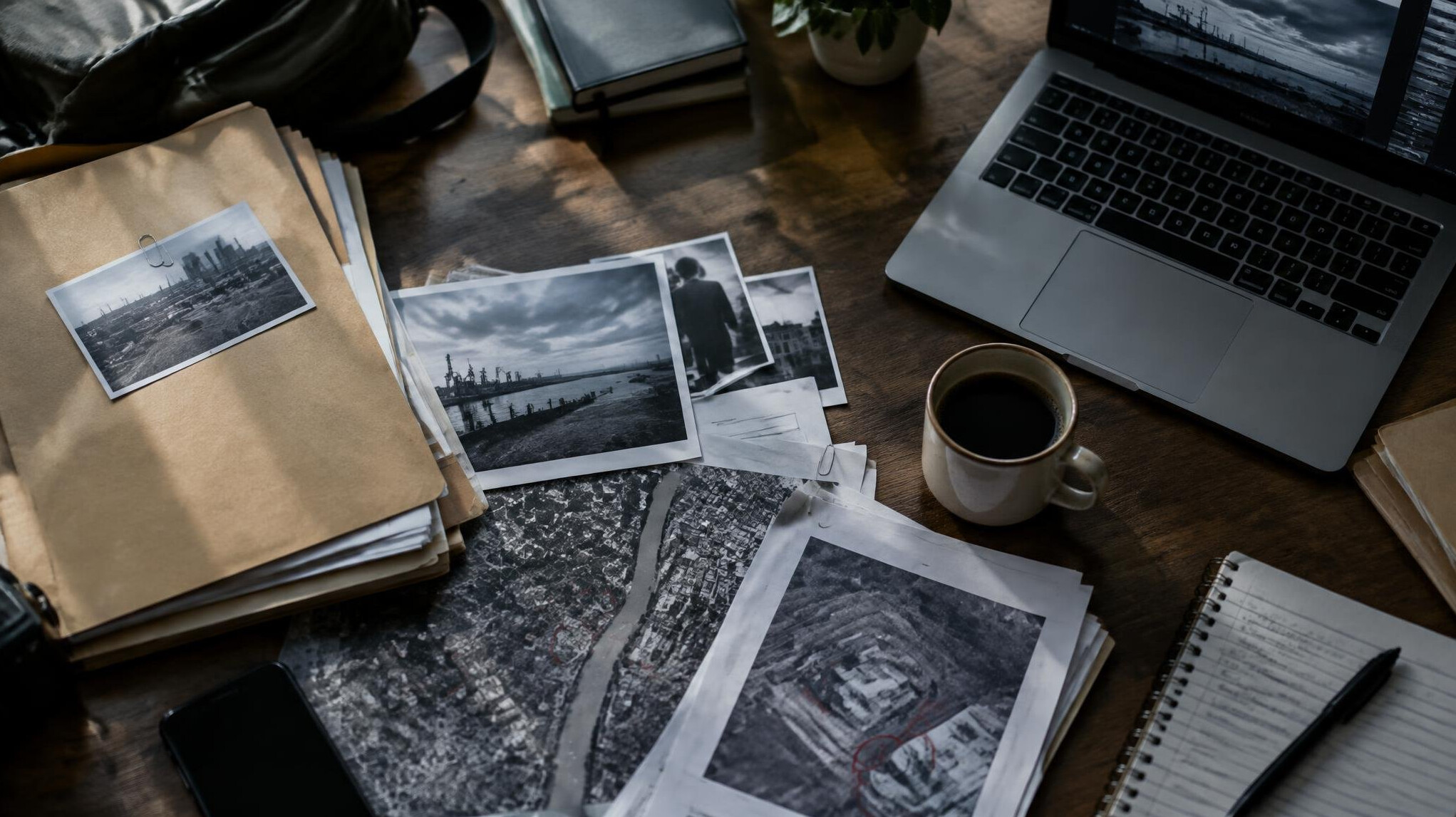 Documents, files and a laptop spread across a desk during an investigation